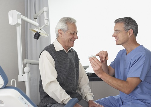 older man sitting talking to male doctor